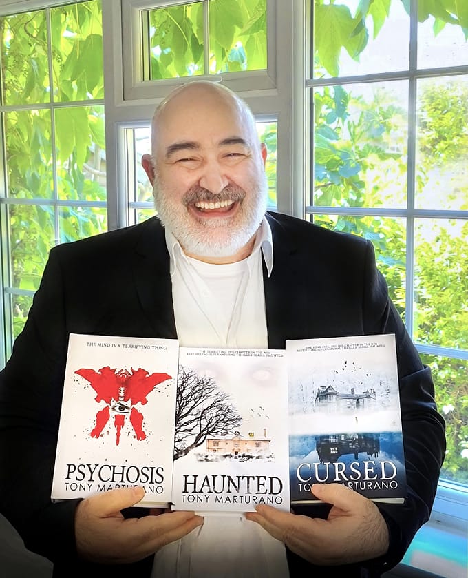 Tony Marturano holding all 3 books from his supernatural haunted series 